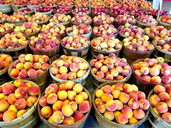 High angle view of peaches in containers at market for sale
