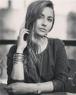 Portrait of young woman with long hair sitting at outdoor cafe