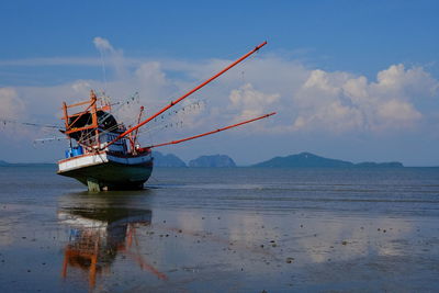 Fishing boat on sea against sky