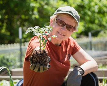 Portrait of smiling woman holding plant