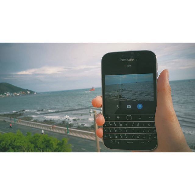 transfer print, lifestyles, sea, leisure activity, auto post production filter, horizon over water, holding, sky, person, water, men, photography themes, photographing, rear view, standing, wireless technology