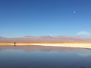 View of calm blue sea against mountain range