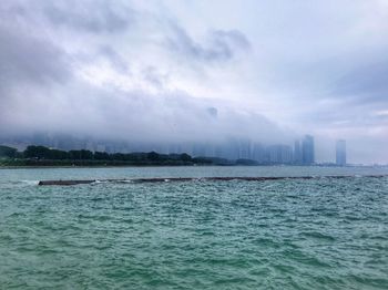 Scenic view of sea by buildings against sky