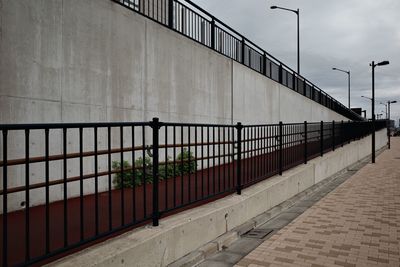 Railing on footpath by wall