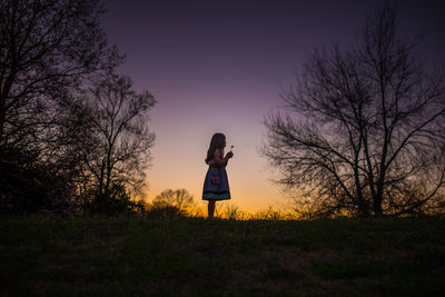 Little girl holding flower silohette long hair summer evening sunset