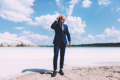 Full length of man standing on beach against sky