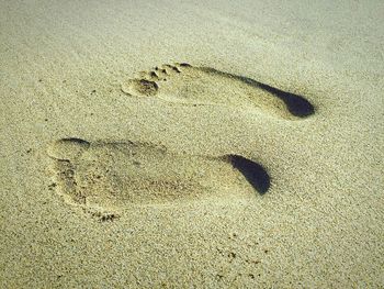 High angle view of footprints at sandy beach