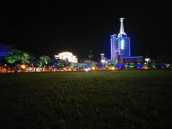 Illuminated cityscape against clear sky at night