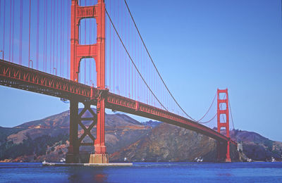 Golden gate bridge over river against blue sky