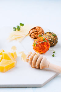 Deep-fried cheese balls on the spice and walnut on the white table, top view. slices of cheese 