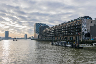 River by buildings against sky in city