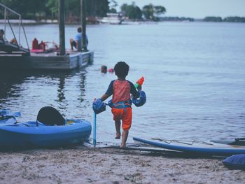 Rear view of boy walking at beach