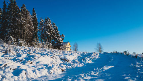 Scenic view of snow covered landscape against clear blue sky