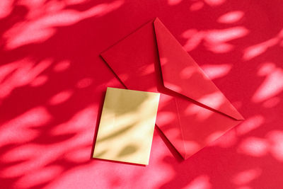 Directly above shot of envelope over red background