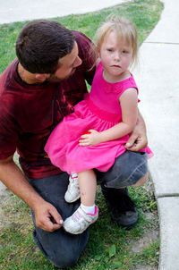 Little girl has a boo boo after a fall and is comforted by her dad