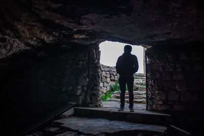 Rear view of man standing against wall