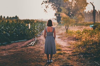 Rear view of woman standing on field