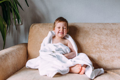 Portrait of smiling girl sitting on sofa