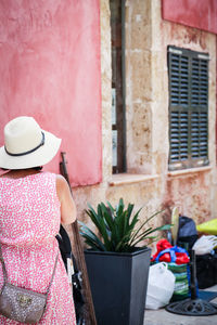 Rear view of person standing by pink flowers