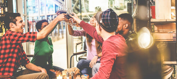 Friends toasting drinks while sitting in restaurant