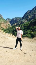 Full length of teenage girl standing against mountain on land