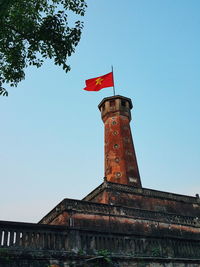 Low angle view of flags against clear sky