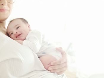 Midsection of father with baby on bed