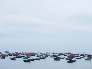 Boats moored in sea against sky