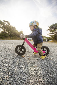 Side view of one year old girl on pink bike. on the move