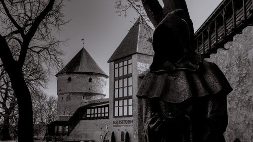 Low angle view of woman standing against built structure