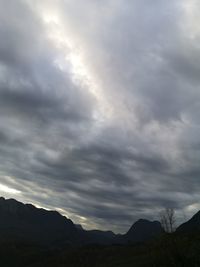 Low angle view of mountains against cloudy sky