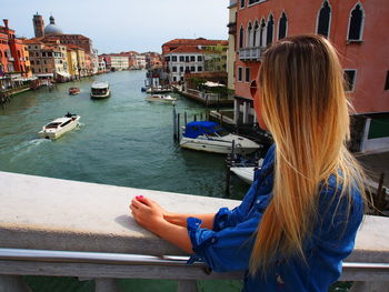 Woman looking at view while standing on bridge over grand canal in city