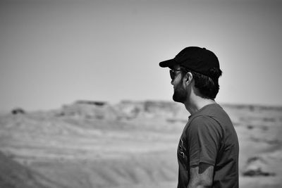 Side view of man looking away against clear sky