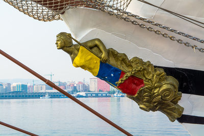 Figurehead on bow of tall ship moored in sea