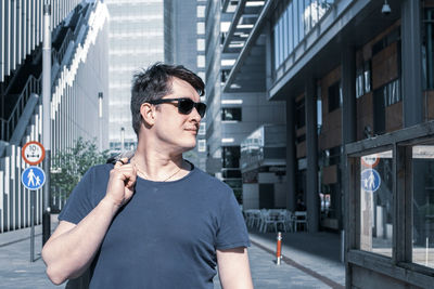 Portrait of young man standing in city