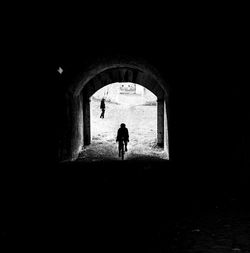 Silhouette man walking in tunnel