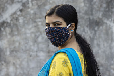 Side face of an indian woman wearing homemade cotton nose mask for corona virus protection