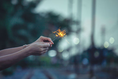 Close-up of hand holding sparkler at night