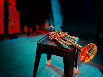 Close-up of trumpet on stool in darkroom