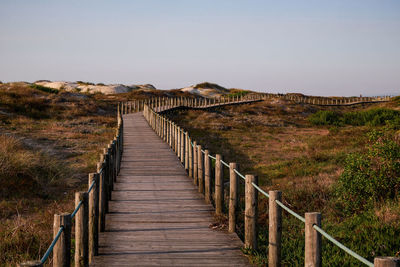 View of wooden bridge against clear sky
