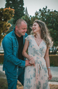 Couple embracing against trees