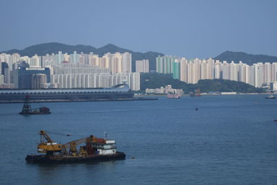 Ship in sea against buildings in city