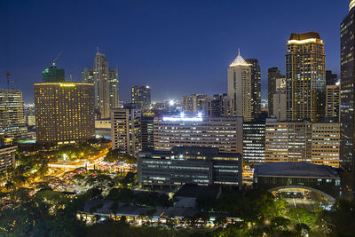 Illuminated buildings in city against sky at night