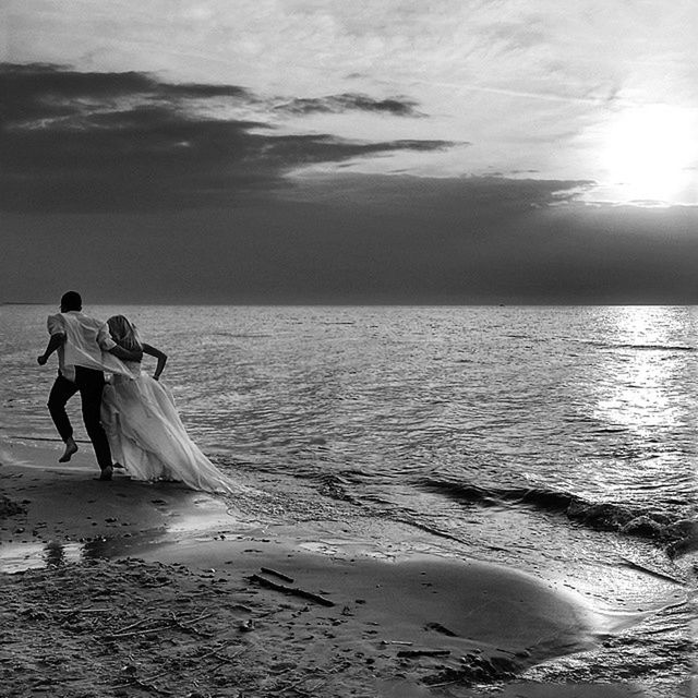 sea, water, horizon over water, beach, sky, lifestyles, leisure activity, shore, scenics, tranquil scene, beauty in nature, tranquility, nature, vacations, men, full length, sand, sunlight