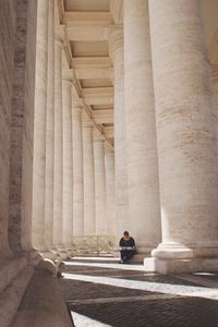 Woman sitting at historical building