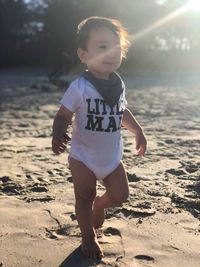 Full length of cute boy walking at beach