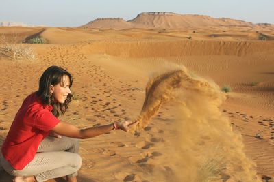 Side view of a woman on sand dune