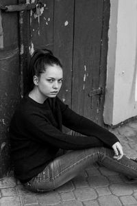 Portrait of young woman sitting on wood