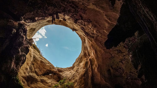 Low angle view of sky seen from cave