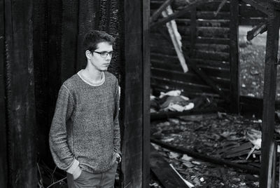 Thoughtful man standing by abandoned built structure